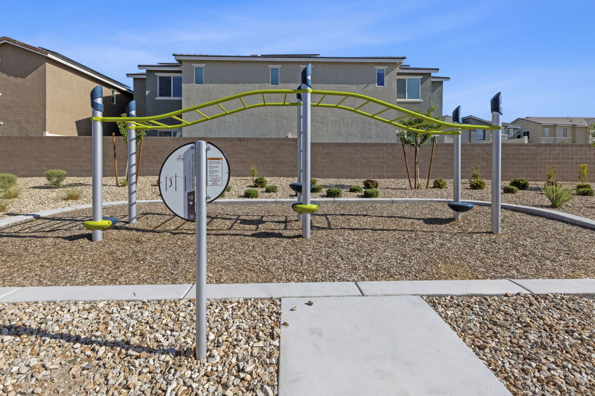 Modern green and grey climbing structure on a wood chip surface at the Watercolor planned community park.