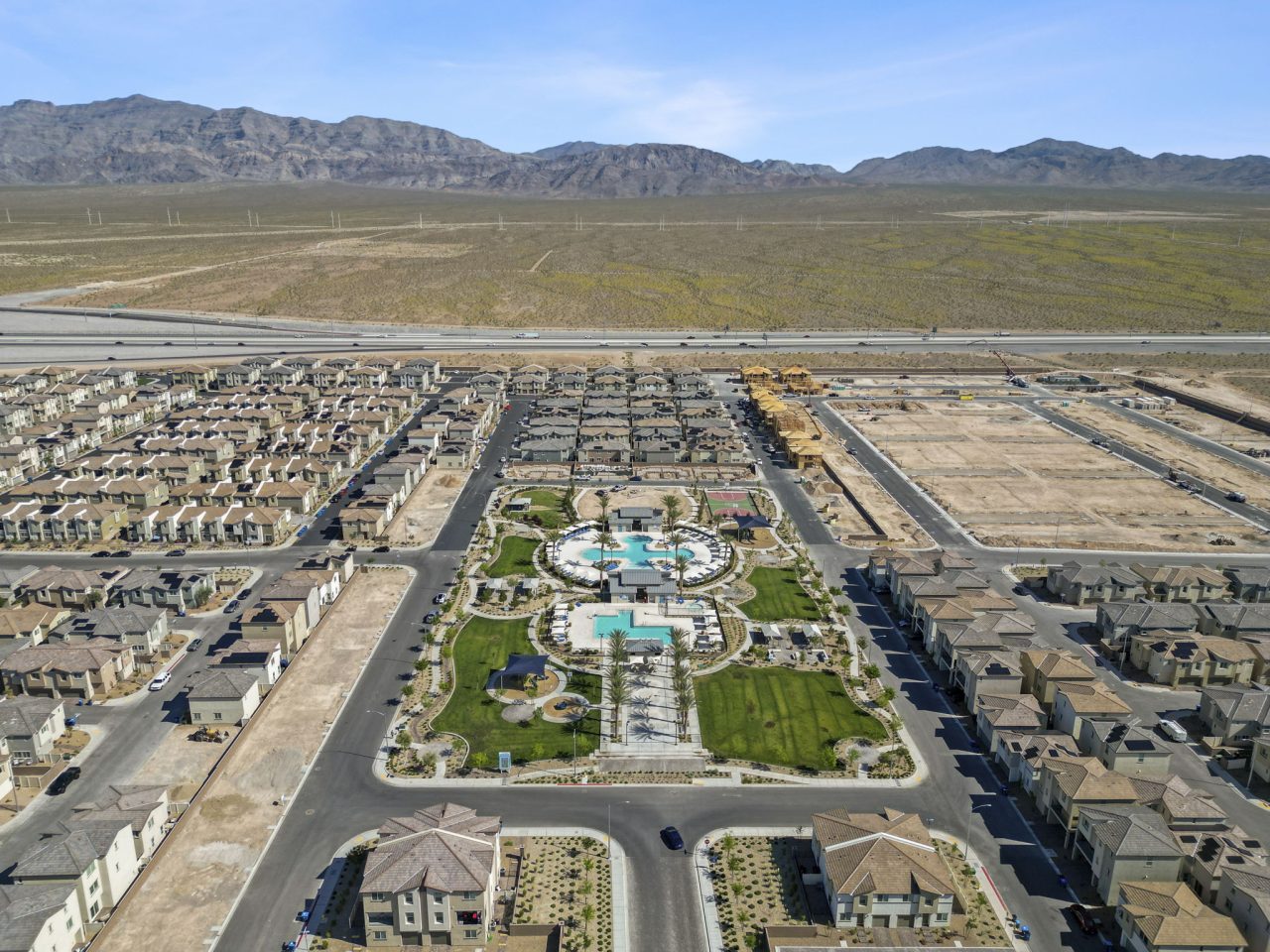High-altitude aerial view of the entire Watercolor planned community showing hundreds of homes, the central amenity park, and surrounding desert.