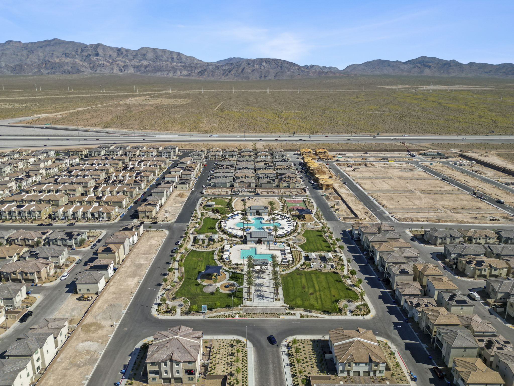 High-altitude aerial view of the entire Watercolor planned community showing hundreds of homes, the central amenity park, and surrounding desert.