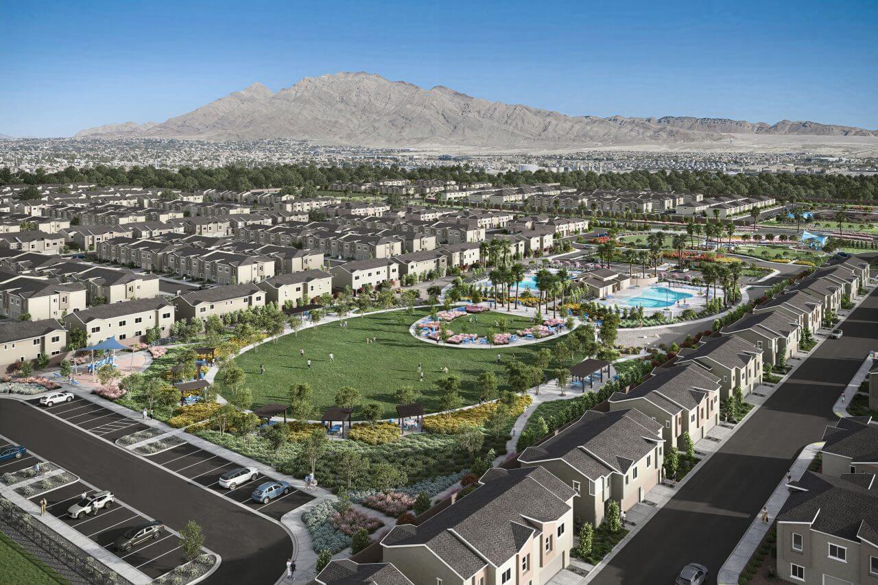Aerial view of the Independence planned neighborhood in East Las Vegas showing a large green central park, two resort-style swimming pools, and rows of modern townhomes with mountains in the background.