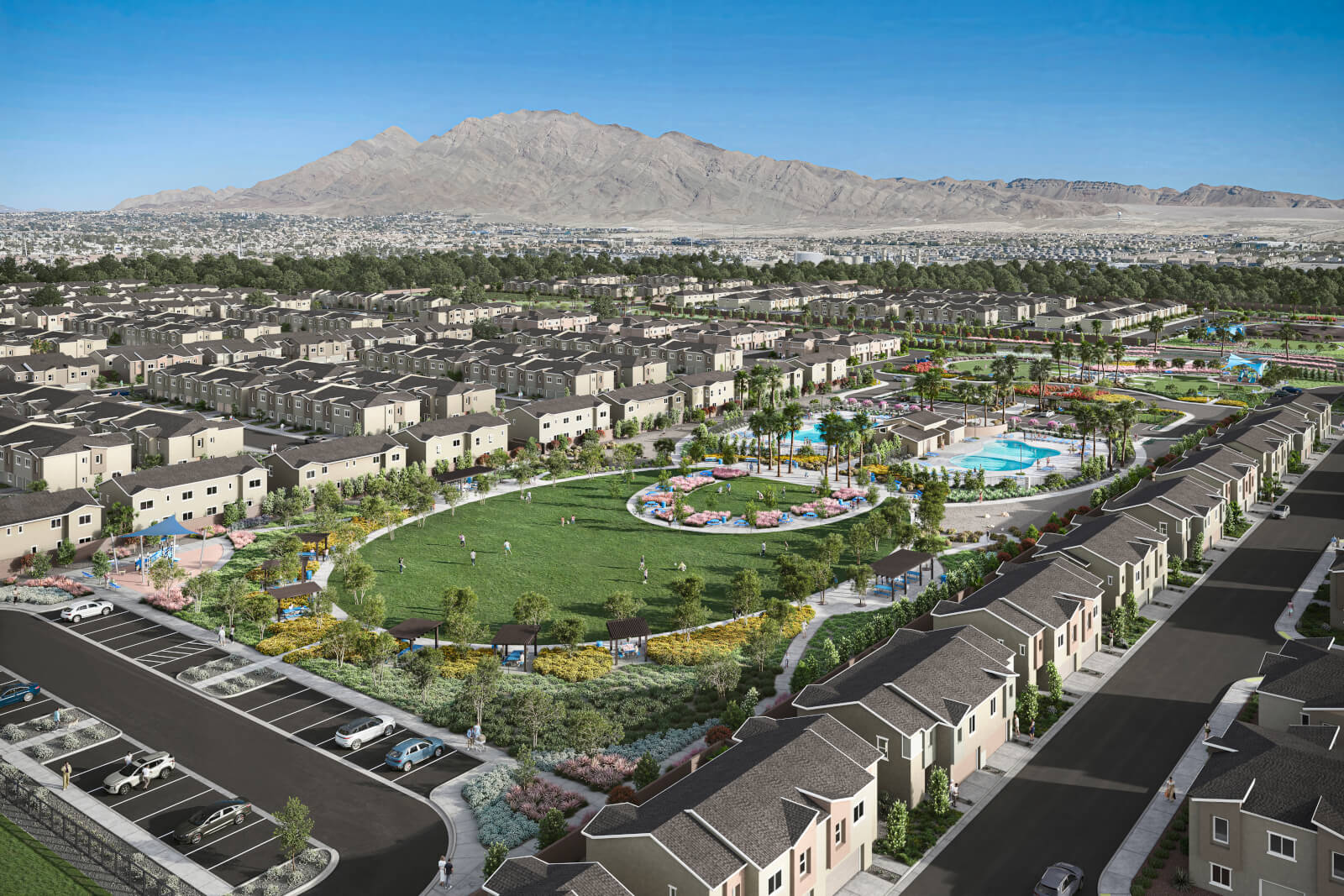 Aerial view of the Independence planned neighborhood in East Las Vegas showing a large green central park, two resort-style swimming pools, and rows of modern townhomes with mountains in the background.