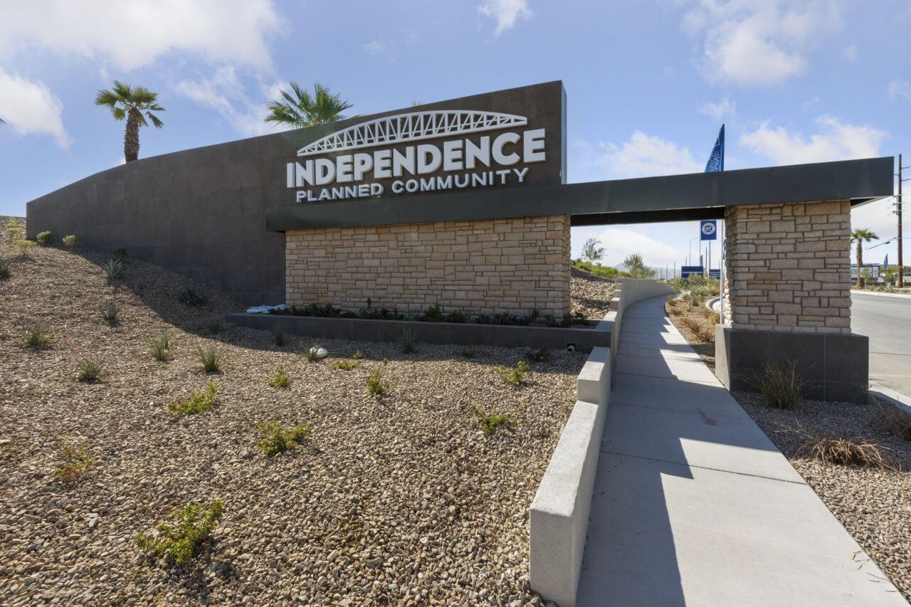 Grand monument sign with stone veneer and desert landscaping confirming the entrance to Independence Planned Neighborhood by Touchstone Living in East Las Vegas.