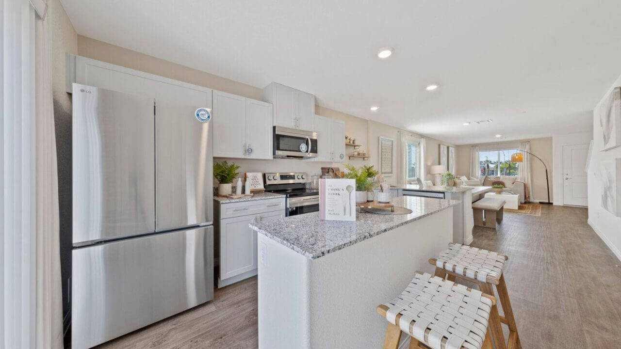 Spacious, open-concept kitchen with new appliances, granite countertops, and a double-door refrigerator.