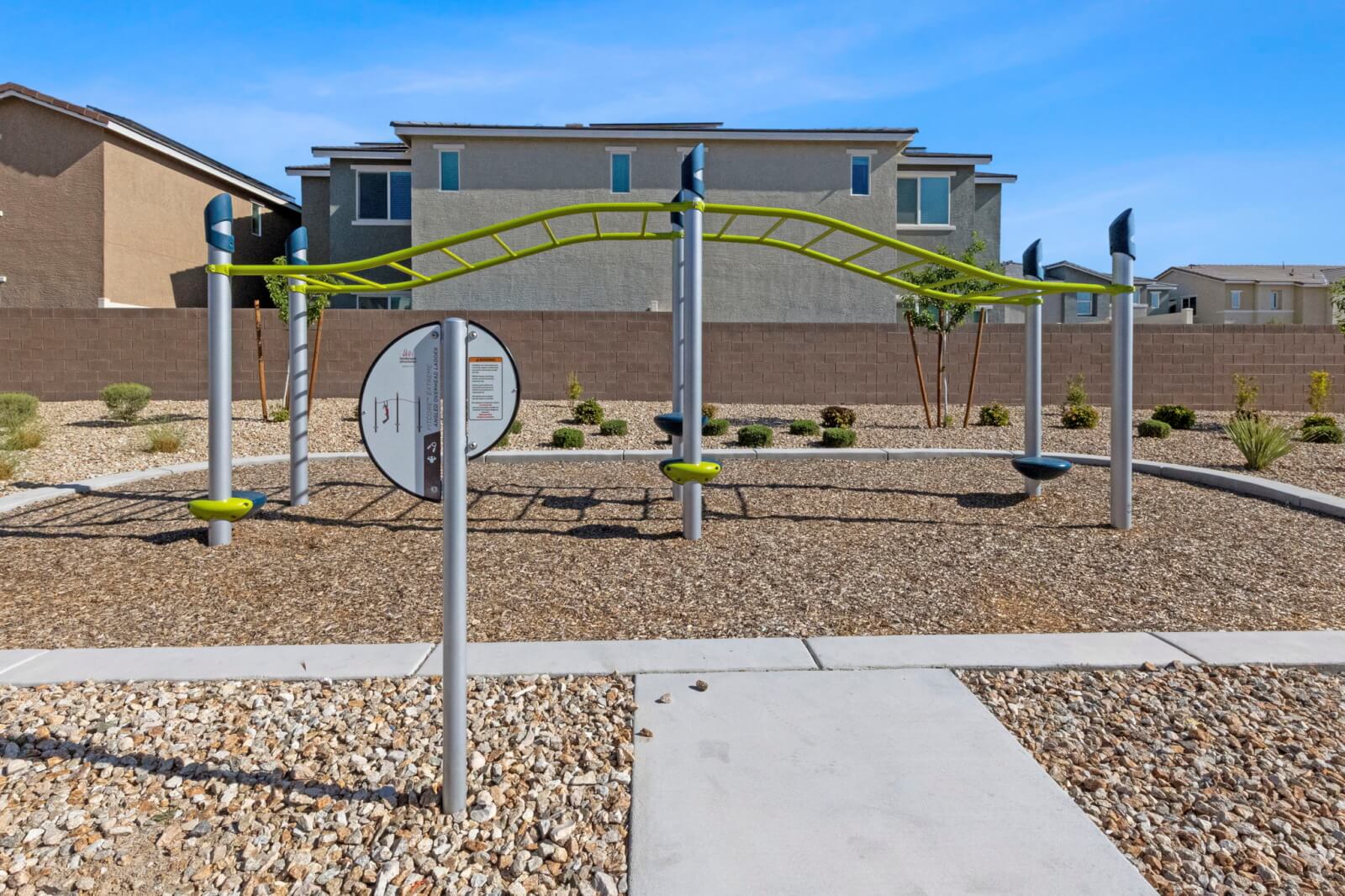 Modern green and grey climbing structure on a wood chip surface at the Watercolor planned community park.