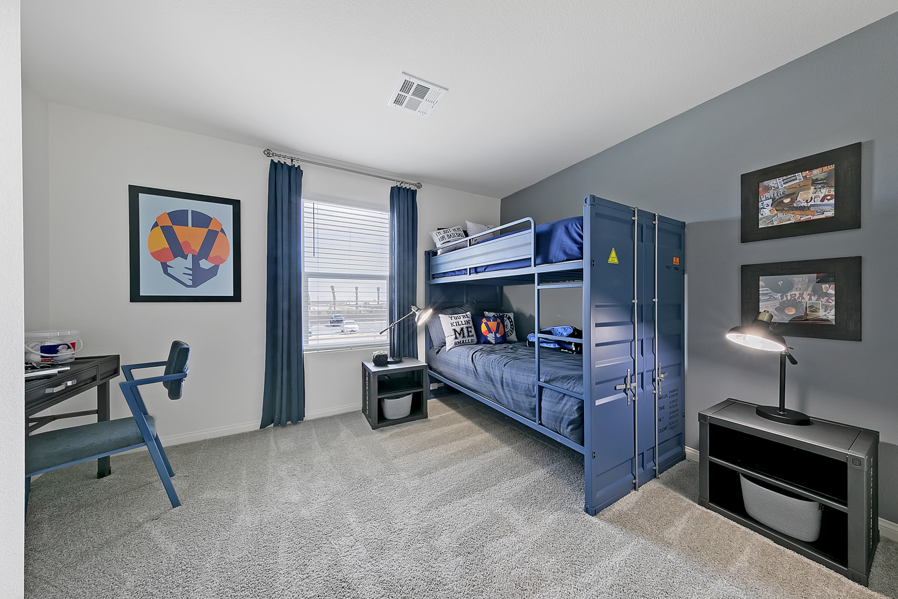 Secondary bedroom featuring a blue shipping container-style bunk bed, a small black desk, and a grey accent wall in a Crimson Plan 520 model home.