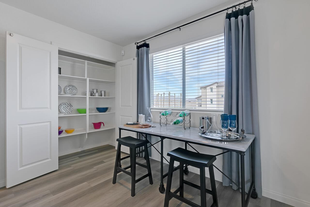 Indigo Plan 543 kitchen pantry and dining space inside a Touchstone Living townhome at the Watercolor neighborhood in North Las Vegas.