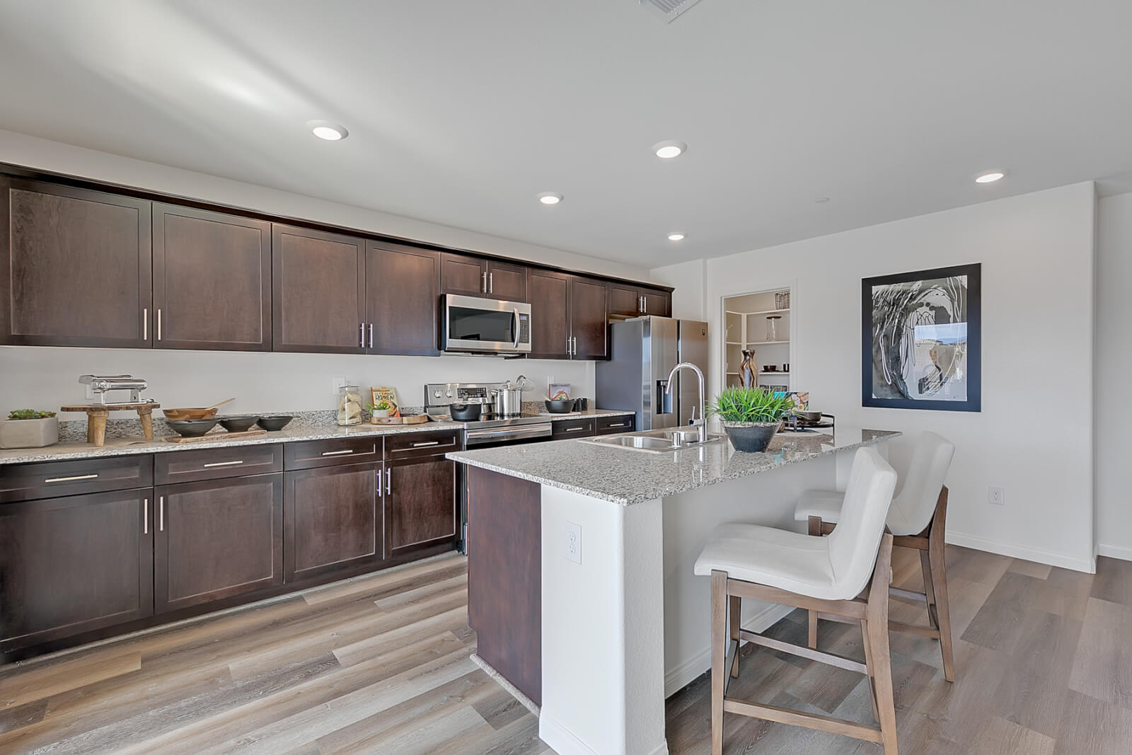 Indigo Plan 544 modern kitchen with dark cabinetry and stainless steel appliances inside a Touchstone Living townhome at Watercolor in North Las Vegas.