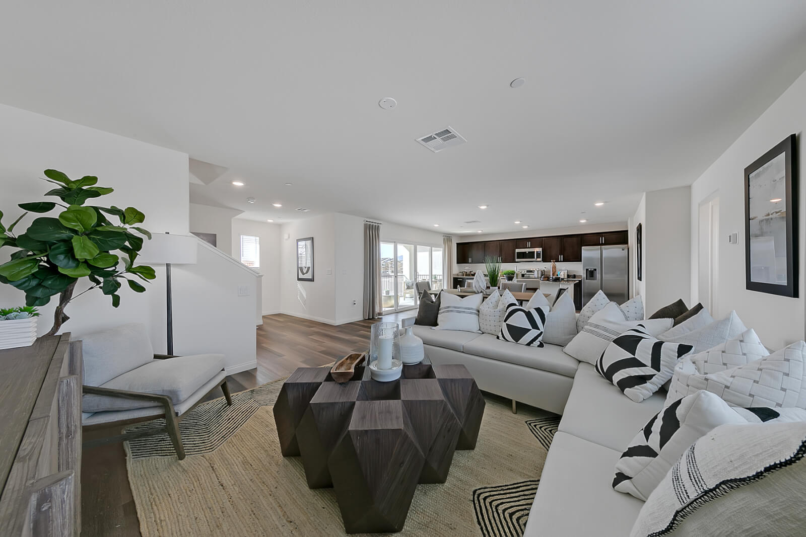 Indigo Plan 544 open-concept living room and kitchen area inside a Touchstone Living townhome at Watercolor in North Las Vegas.