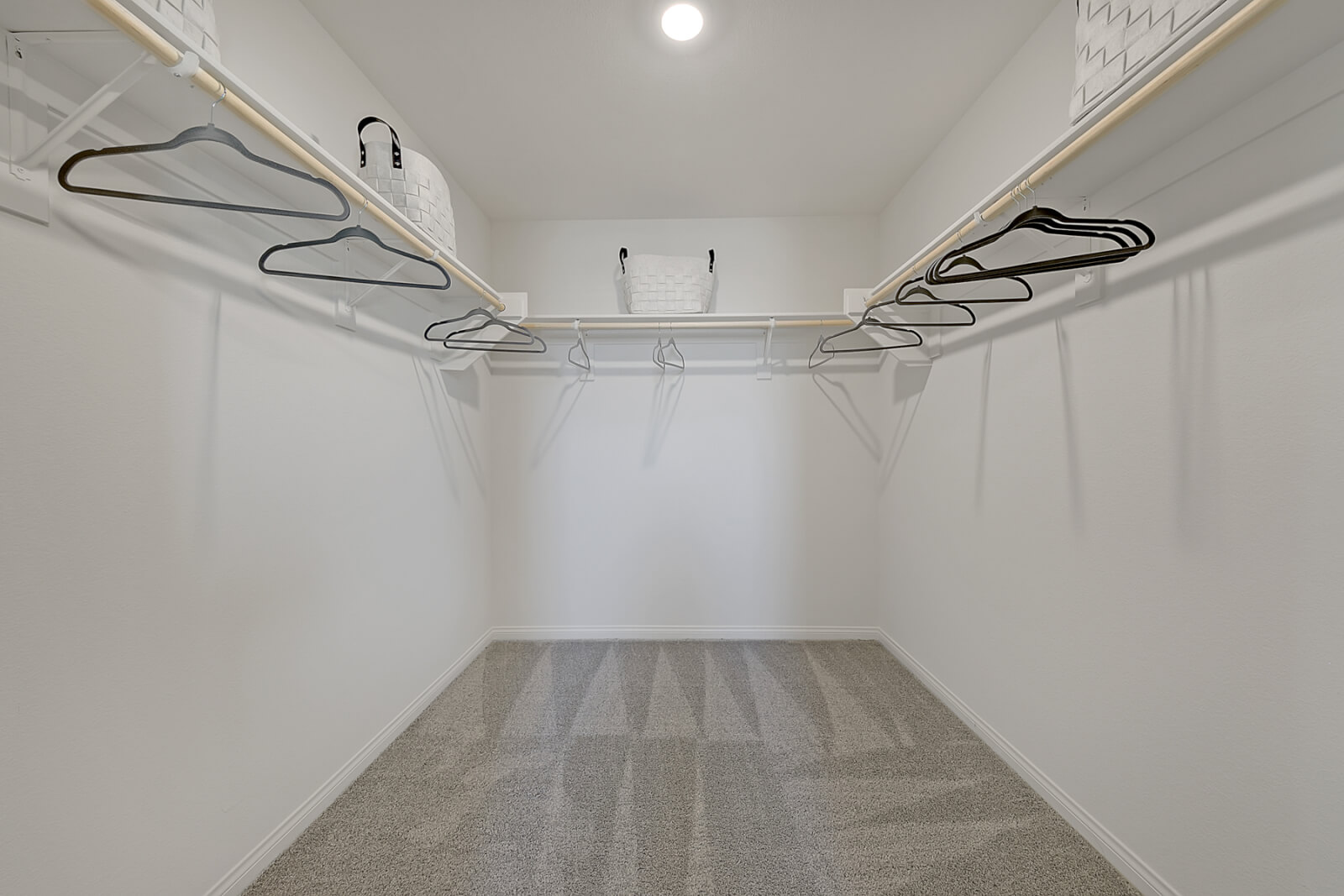 Crimson Plan 520 master walk-in closet with built-in organization and beige carpeting inside a Touchstone Living townhome at Watercolor in North Las Vegas.